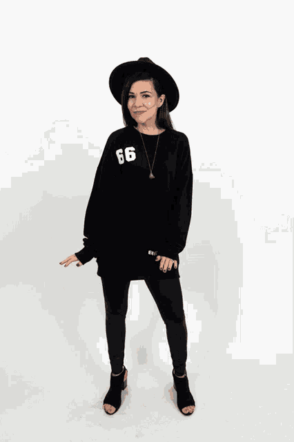 a woman wearing a black sweatshirt with the number 66 on the front
