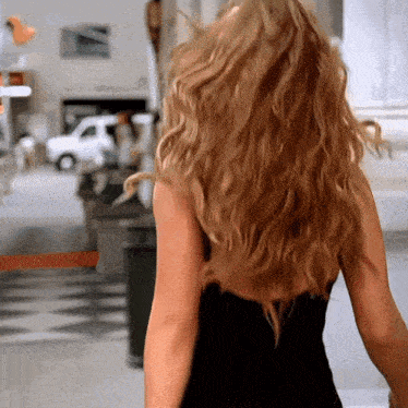 a woman in a black dress is standing in front of a sign that says ' valet parking ' on it