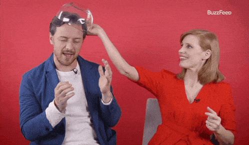 a woman in a red dress holds a glass over a man 's head with buzzfeed written on the bottom