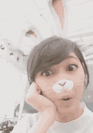 a woman is wearing bunny ears and a cat mask on her face .
