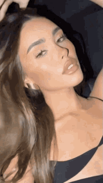 a close up of a woman 's face in a black top