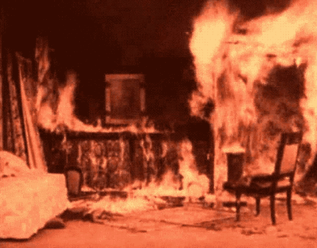 a room that is on fire with a chair and a couch