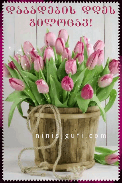 a bouquet of pink flowers in a wooden bucket with the website ninisjgufi.com written below it
