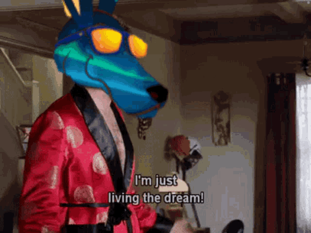 a man in a red robe with a blue animal head says i 'm just living the dream