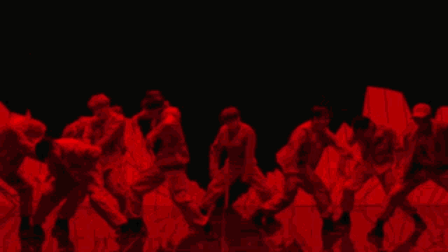 a group of people are dancing in a red light