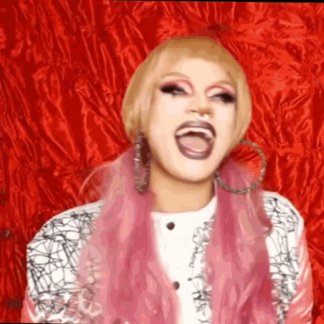 a drag queen with blonde hair and pink hair is making a funny face .