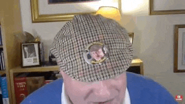 a man wearing a plaid hat with a picture of a man on it .