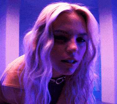 a woman with blonde hair and purple lights behind her