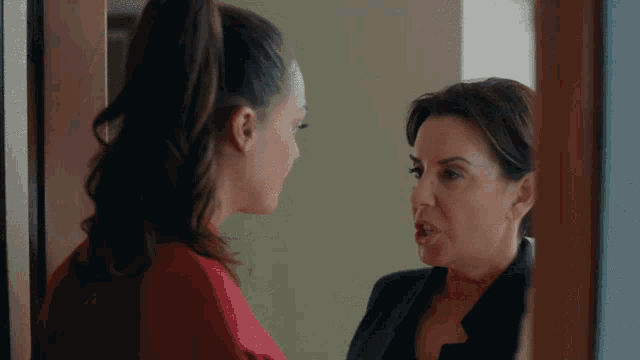two women are standing next to each other and talking to each other