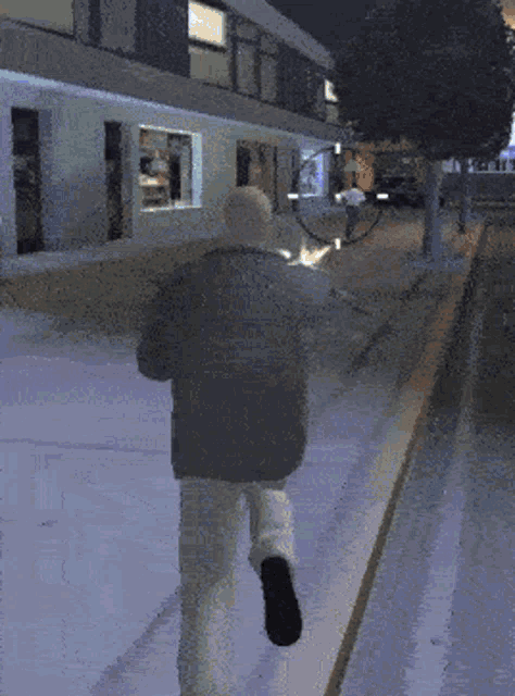 a man in a black jacket is running down the street
