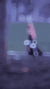 a blurred image of a person standing in front of a tree .