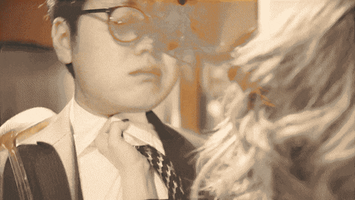a man in a suit and tie adjusts his tie in front of chewbacca