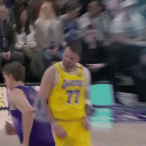 a basketball player wearing a yellow jersey with the number 77