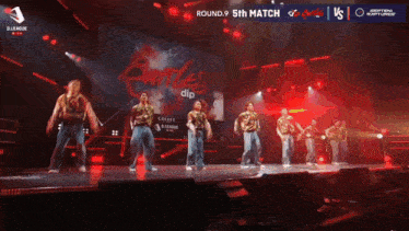 a group of people are dancing on a stage in front of a sign that says round 9 51th match