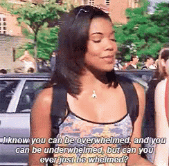a woman with a backpack is standing in front of a car talking to someone .