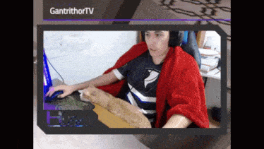 a man sitting at a desk with a cat on his lap and the words gantrithorntv on the bottom right