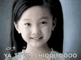 a little girl with long hair is smiling and saying `` ya te vi ! chiquitoooo '' .
