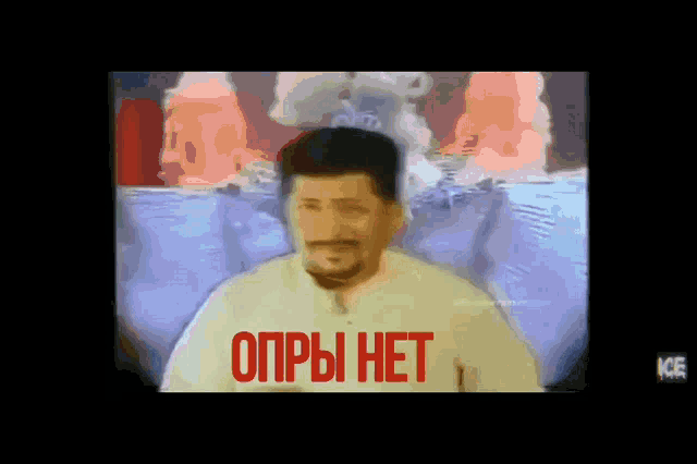 a man with a beard and mustache is standing in front of a sign that says ' opbi het '