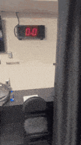 a digital clock hanging on a wall displays the time as 0:00