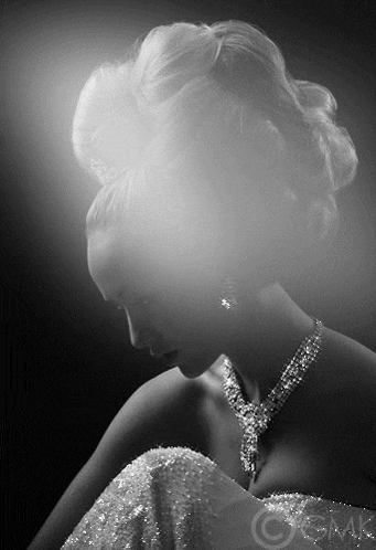 a black and white photo of a woman wearing a dress and a necklace