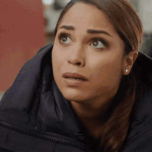 a woman with a surprised look on her face wearing a black jacket .