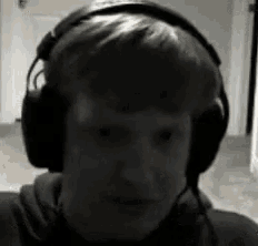 a young man wearing headphones looks at the camera .