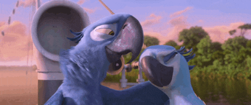 two blue birds are standing next to each other and looking at each other