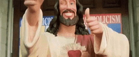 a statue of jesus with a beard is giving a thumbs up sign .