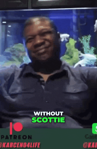 a man sitting in front of an aquarium with the words " without scottie " on the top