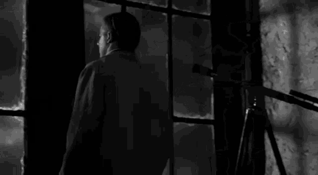 a black and white photo of a man standing in front of a hanger with the words `` success '' written on the bottom .