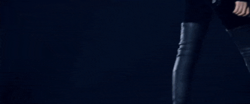 a woman with red hair is wearing a headset and singing into a microphone in a dark room .