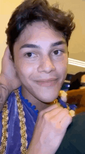 a close up of a young man 's face with a person holding his head .
