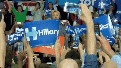 a crowd of people are holding up signs that say hillary