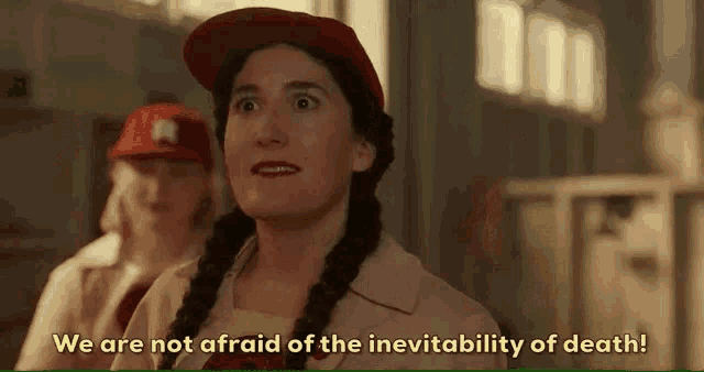 a woman wearing a red hat is talking about the inevitability of death .