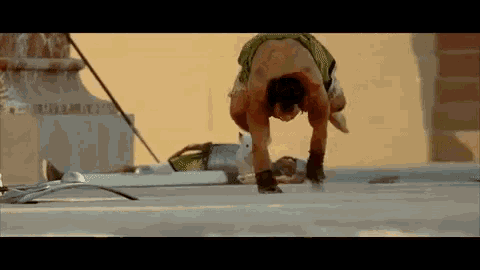 a shirtless man is doing a handstand on a roof