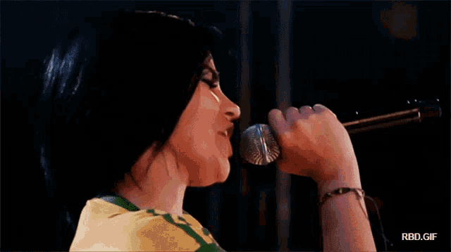 a close up of a woman singing into a microphone