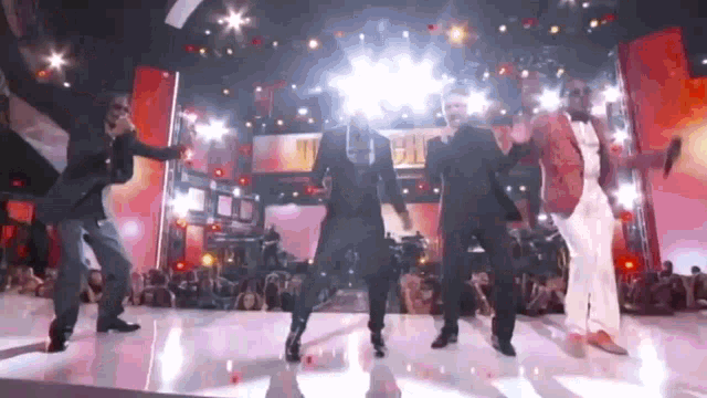 a group of men are dancing on a stage .