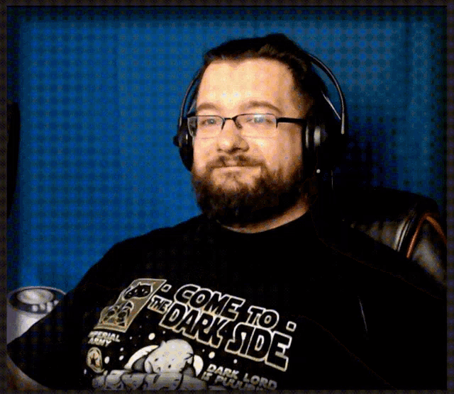 a man wearing headphones and a black shirt that says " come to the dark side "