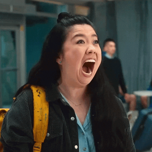 a woman is making a funny face with her mouth wide open .