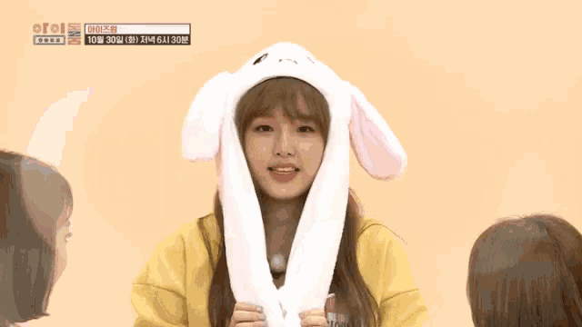 a girl wearing a bunny hat with korean writing