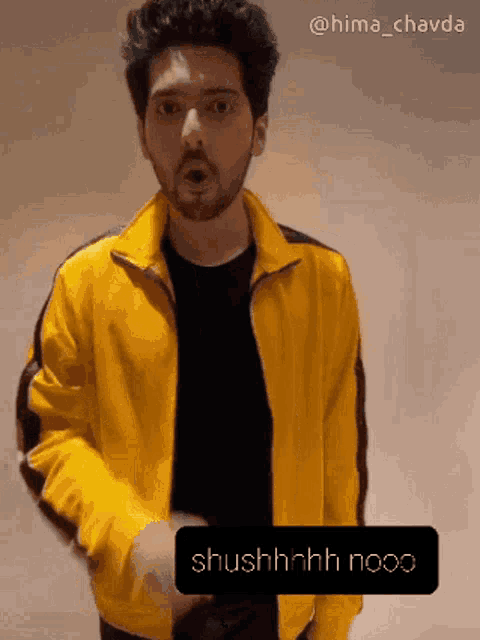 a man is wearing a yellow jacket and a black shirt and says shushhhh nooo