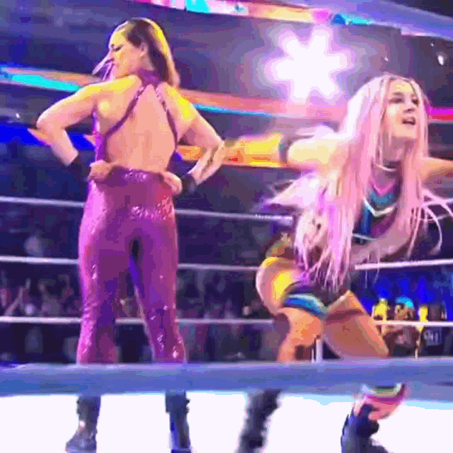two women are wrestling in a ring and one of them has pink hair