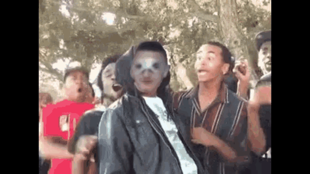 a group of young men are dancing in a park .
