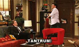 two men are sitting on a couch and one is sitting in a red chair with the word tantrum written on the bottom
