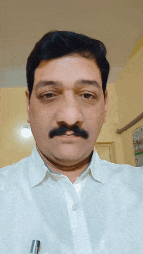 a man with a mustache is wearing a white shirt and a pen in his pocket