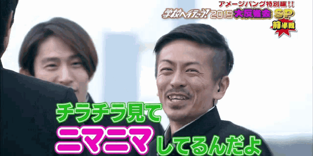 a man is smiling in front of a sign that says ' 2015 sp '