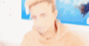 a blurry picture of a young man wearing a tan hoodie .