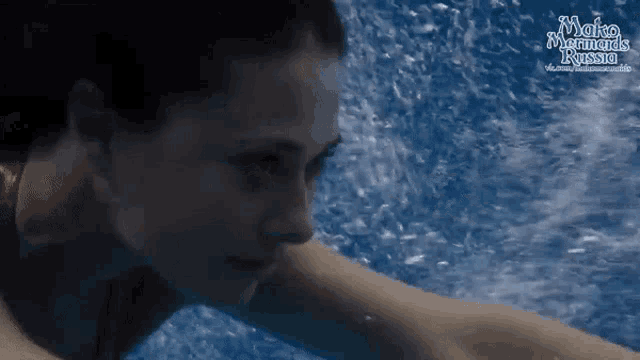 a woman is swimming in a pool with the words mako mermaids rising above her