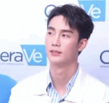 a young man is sitting in front of a sign that says era ve .