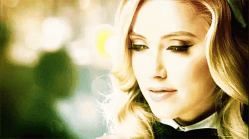 a close up of a woman 's face wearing a bow tie